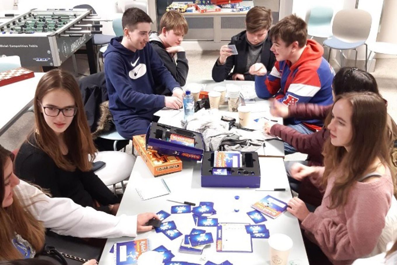 Elevene sitter rundt bordet og spiller brettspill.