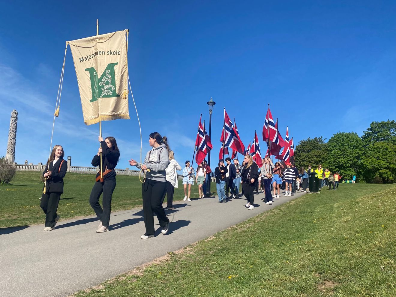 Øvetoget med Majrostuen skoles fane i front med Monolitten i bakgrunnen