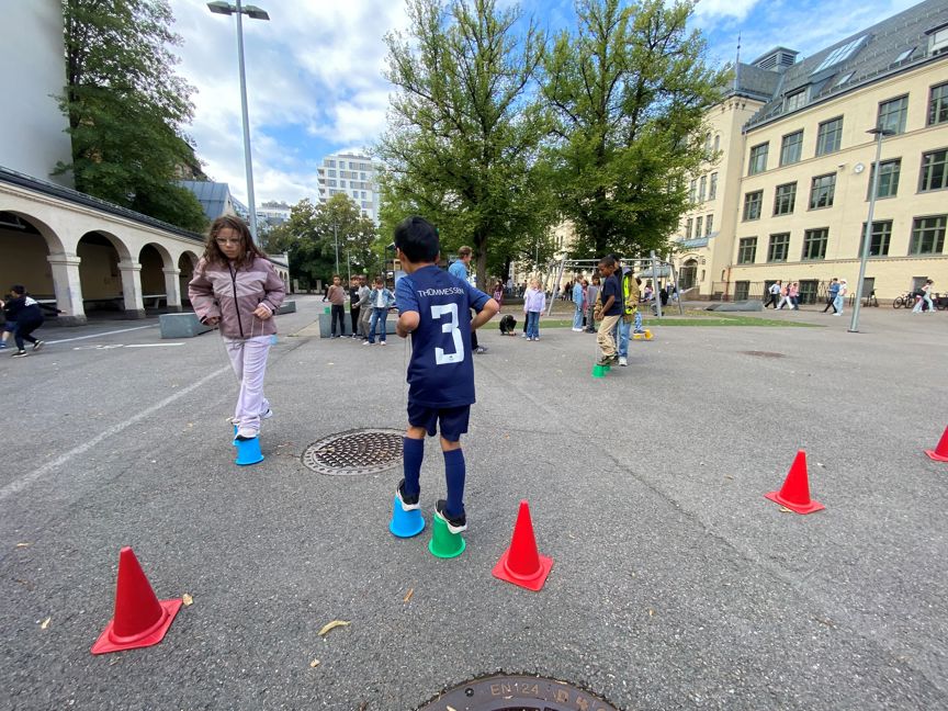 et barn som sto på en parkeringsplass med kjegler rundt seg