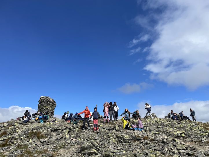 En gruppe mennesker på en steinete høyde