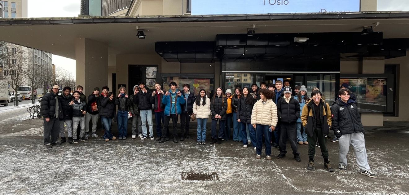 en gruppe mennesker som poserer for et bilde utenfor en bygning