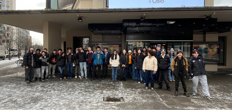 en gruppe mennesker som poserer for et bilde utenfor en bygning