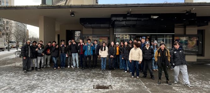 en gruppe mennesker som poserer for et bilde utenfor en bygning en gruppe mennesker som poserer for et bilde utenfor en bygning