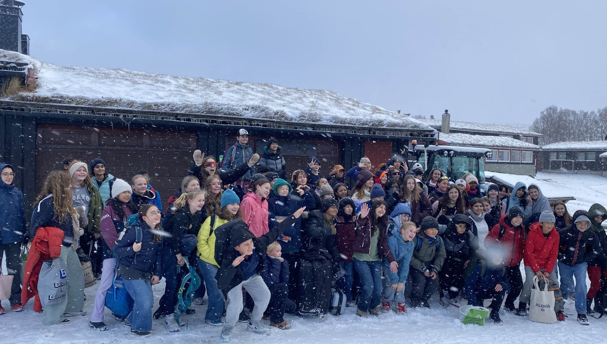 en gruppe mennesker som poserer for et bilde foran en bygning