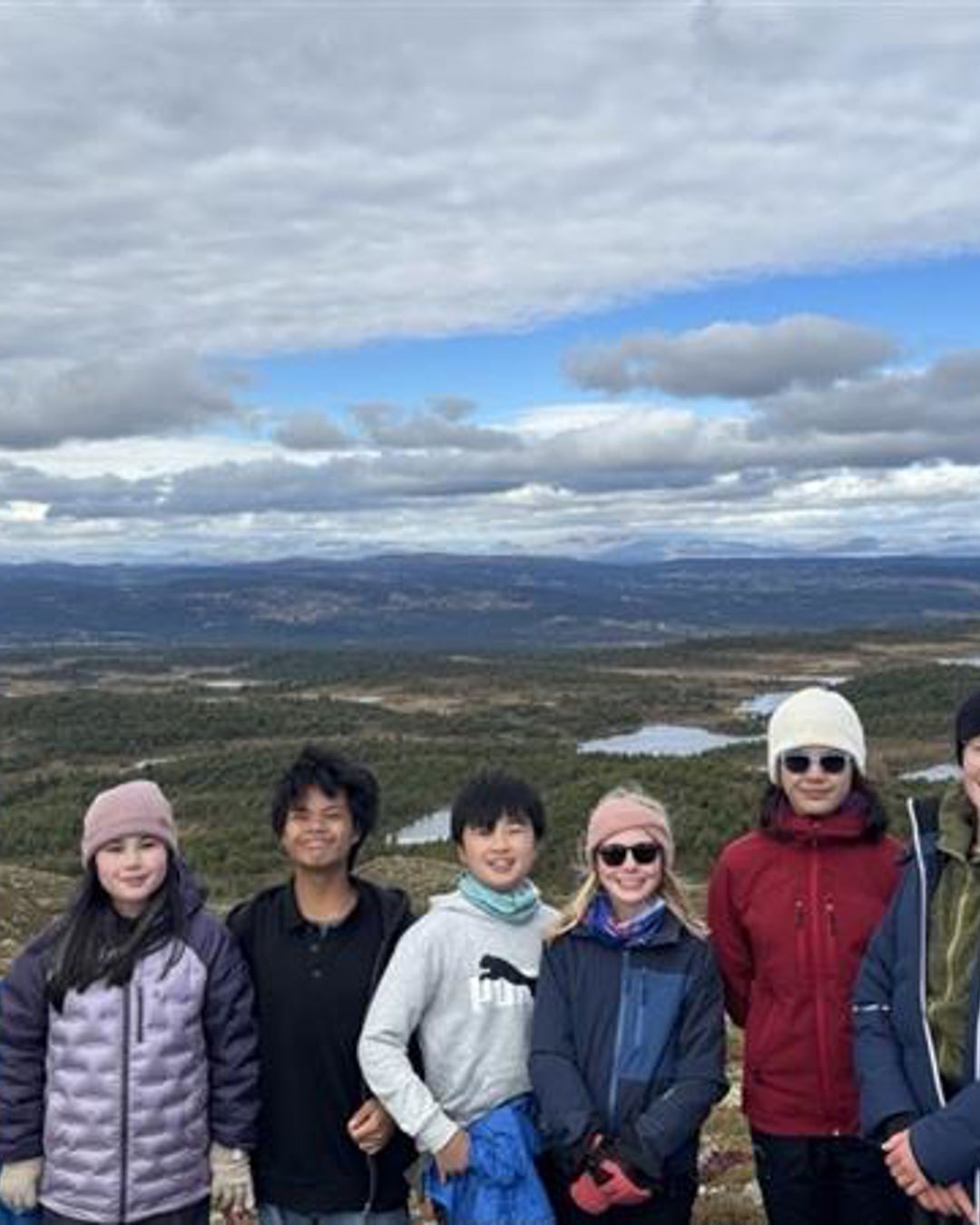 en gruppe mennesker poserer for et bilde med et snødekt landskap i bakgrunnen en gruppe mennesker poserer for et bilde med et snødekt landskap i bakgrunnen